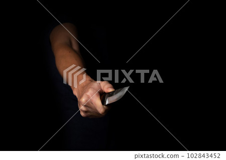 Adult Man Holding Sharp Knife in the Shadow. Concept Picture of Murderer, Killer, Assasin, Robber or Theft 102843452