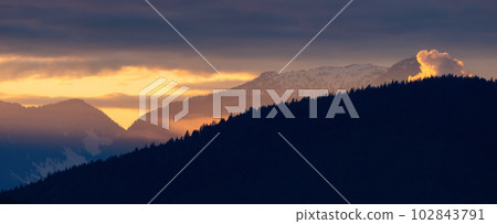 Colorful Puffy Clouds over the Mountain Landscape during dramatic Sunset. 102843791
