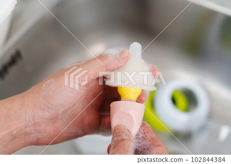 mother hand washing the baby nipple of milk bottle mother hand washing the baby nipple of milk bottle 102844384