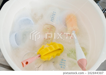 bottle of milk with brush are washing in basin 102844387