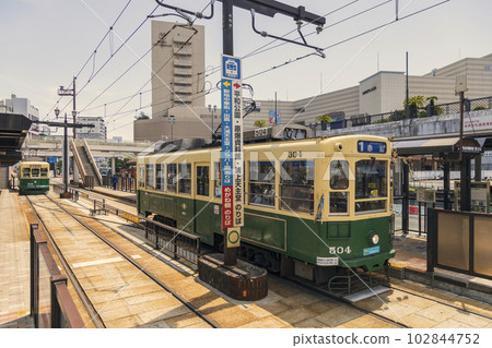 A tram running through the city of Nagasaki A tram running through the city of Nagasaki 102844752