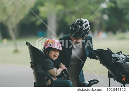 Wearing a bicycle helmet for both mother and child 102845112