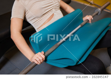 Close-up of a woman doing deadlift exercise alone at the gym. Close-up of a woman doing deadlift exercise alone at the gym. 102845147