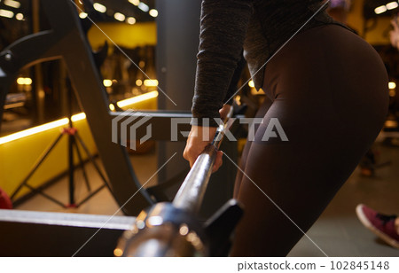 Close-up of a woman doing deadlift exercise alone at the gym. 102845148