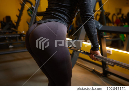 Close-up of a woman doing deadlift exercise alone at the gym. 102845151