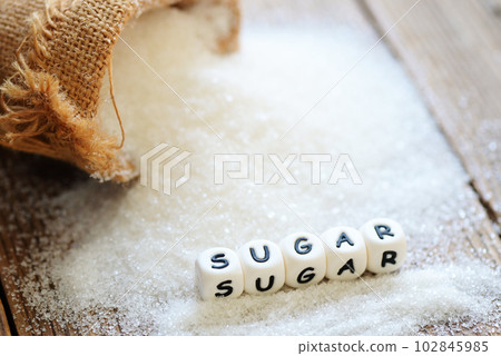 white sugar for food and sweets dessert candy heap of sweet sugar crystalline granulated, Sugar on sack and wooden background 102845985