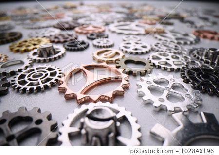 Various metal gears from disassembled device lie at table 102846196