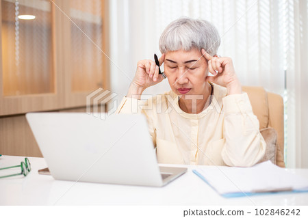 Asian senior business woman stress from hard work, Female manager headache sitting at table. Asian senior business woman stress from hard work, Female manager headache sitting at table. 102846242