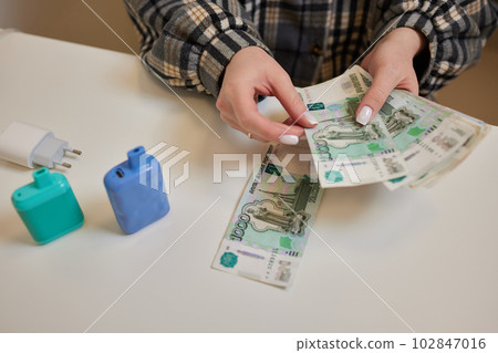 Russian rubles in the hand of a fan.male hand holding many of the Russian banknotes.The transfer of money.The isolated five-thousandth of Russian rubles denominations in a hand. Russian rubles in the hand of a fan.male hand holding many of the Russian banknotes.The transfer of money.The isolated five-thousandth of Russian rubles denominations in a hand. 102847016