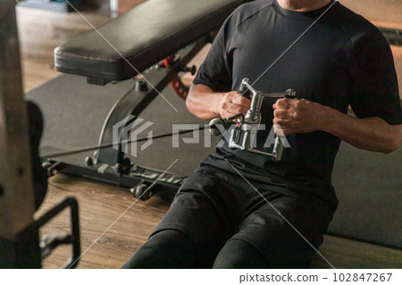 亞洲男子在健身房用電纜機進行肌肉訓練 102847267