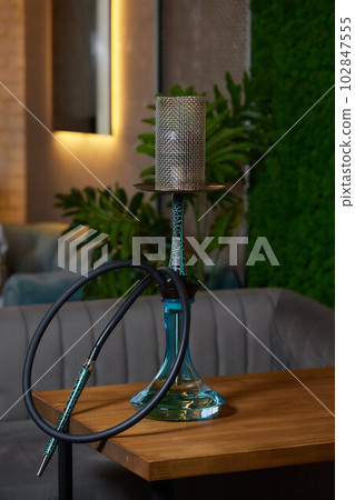 Wood hookah on table in hookah lounge. Wood hookah on table in hookah lounge. 102847555