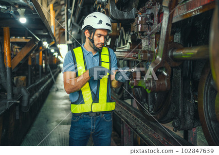 worker working in an industrial factory uses a cross screwdriver to inspect the machine. worker working in an industrial factory uses a cross screwdriver to inspect the machine. 102847639