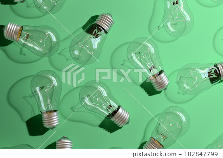 Close-up of an incandescent lamp on green background. 102847799
