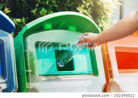 people hand holding garbage bottle plastic putting into recycle bin for cleaning people hand holding garbage bottle plastic putting into recycle bin for cleaning 102848022
