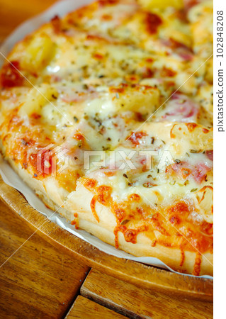 Close focus on homemade hawaiian pizza covered after baking from oven. 102848208