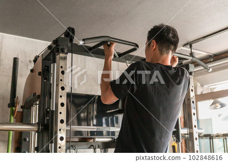 一個在健身房使用機器訓練的人(引體向上) 一個在健身房使用機器訓練的人(引體向上) 102848616