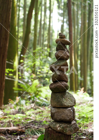 A stone marker made by piling up pebbles in the forest A stone marker made by piling up pebbles in the forest 102850121
