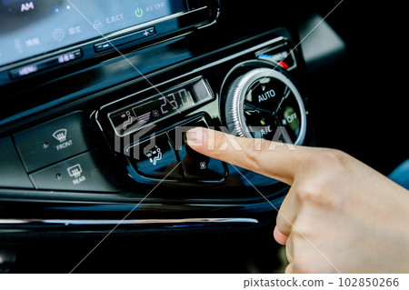 The hand that adjusts the car's air conditioning 102850266