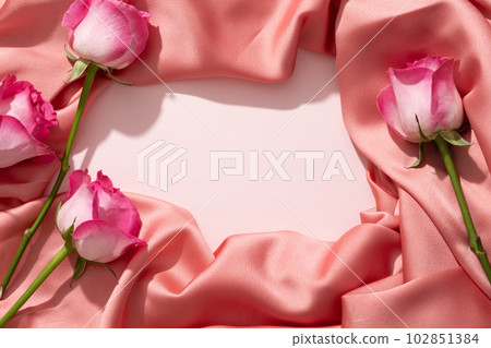 The luxurious pink fabric folded and created a vacant space in the center for natural beauty product presentation. Some Roses (Rosa) are displayed 102851384