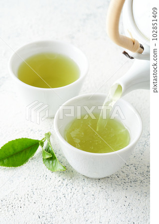 Green tea brewed in a teapot 102851409