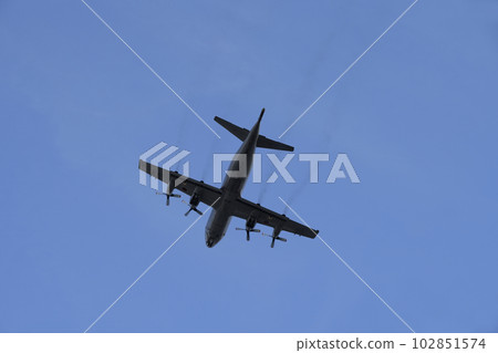 A C-130 transport plane flying through the blue sky A C-130 transport plane flying through the blue sky 102851574