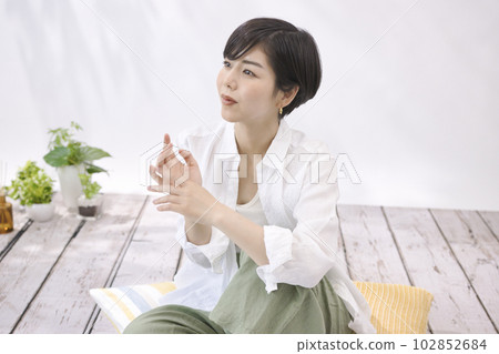 坐在客廳裡放鬆的年輕女人 102852684
