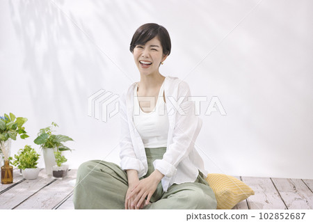 Young woman sitting and relaxing in living room Young woman sitting and relaxing in living room 102852687