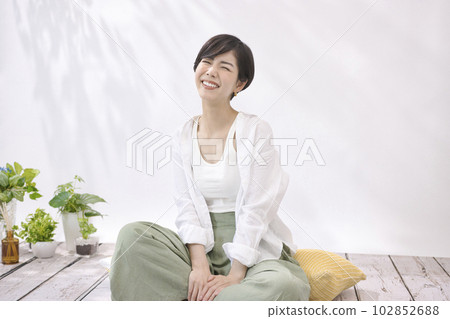 Young woman sitting and relaxing in living room 102852688