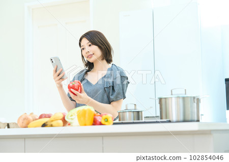 Young woman looking at a cooking recipe Young woman looking at a cooking recipe 102854046