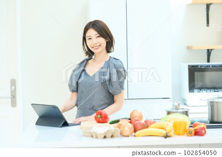Young woman looking at a cooking recipe Young woman looking at a cooking recipe 102854050
