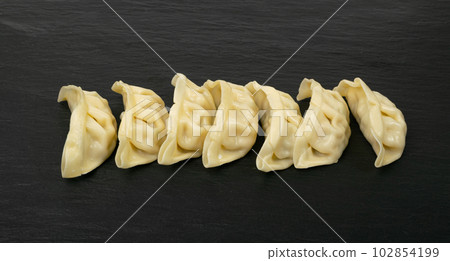 Gyoza Chinese Dumplings, Steamed Vegetable Jiaozi, Chicken Momo Pile, Asian Gyoza Group on Black Stone Gyoza Chinese Dumplings, Steamed Vegetable Jiaozi, Chicken Momo Pile, Asian Gyoza Group on Black Stone 102854199