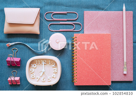 Pink stationery office supply on blue fabric desk background. flat lay, top view 102854810