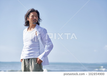 Elderly man looking far away at the beach Portrait 102854900