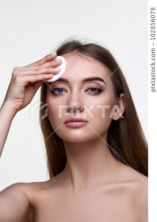 woman holding white cotton pad for removing makeup 102856078