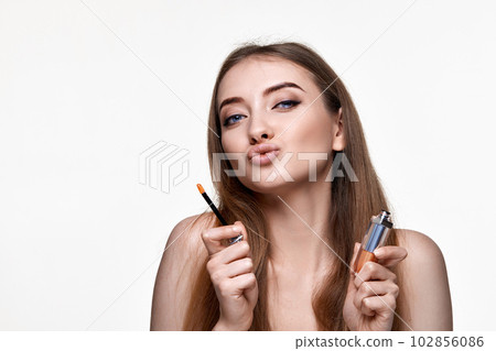 beautiful young woman with pouted lips holding lip gloss beautiful young woman with pouted lips holding lip gloss 102856086