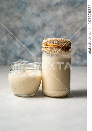 Sourdough starter in jars. Healthy wild fresh homemade yeast for sourdough bread baking. 102856223