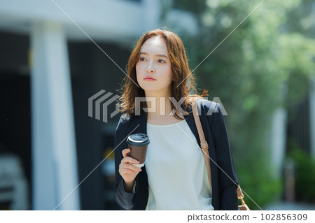 A woman walking outdoors 102856309