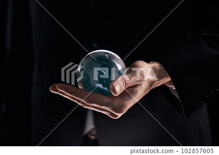 businessman Hand holding glass ball on black background 102857605