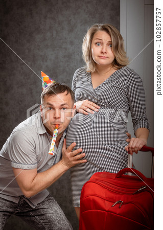 Beautiful amazed pregnant woman with husband ready for childbirth. Wife having contraction. Happy family going to maternity hospital. 102857757