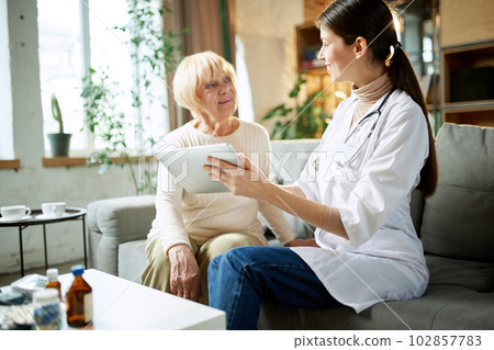 Senior woman at appointment, consultation checking health in clinic, hospital on daytime, talking with doctor 102857783