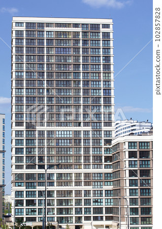 Modern high-rise buildings made of concrete and glass. Construction site. The final stage of construction. Against the background of the blue sky. Modern high-rise buildings made of concrete and glass. Construction site. The final stage of construction. Against the background of the blue sky. 102857828