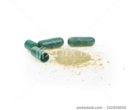 Green powder and herbal medicine capsule isolated on white background. Green powder and herbal medicine capsule isolated on white background. 102858039