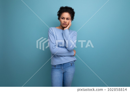 bored young 20s woman with afro hair model appearance thinking in studio bored young 20s woman with afro hair model appearance thinking in studio 102858814
