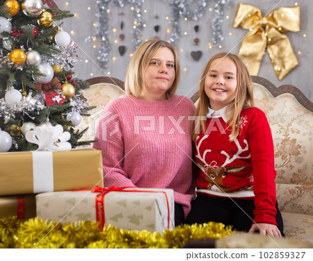 Mom and daughter on sofa in Christmas interior Mom and daughter on sofa in Christmas interior 102859327