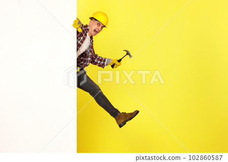 professional builder in work clothes in helmet holding hammer. 102860587