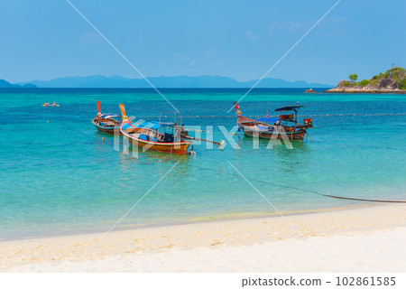 Sunrise Beach in Ko Lipe, Thailand. Long-tail boats in azure water Sunrise Beach in Ko Lipe, Thailand. Long-tail boats in azure water 102861585