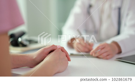 Patient hands on table during visit to doctor in clinic closeup 102861679