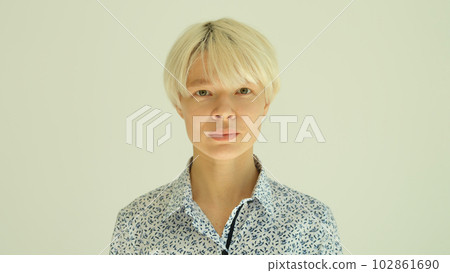 Portrait of young blonde woman with short haircut in shirt on white background 102861690