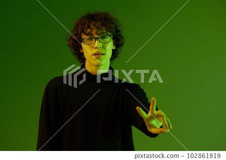 Man young man portrait in glasses fashion happiness and smile, hipster lifestyle, portrait green background mixed neon light, copy space 102861919