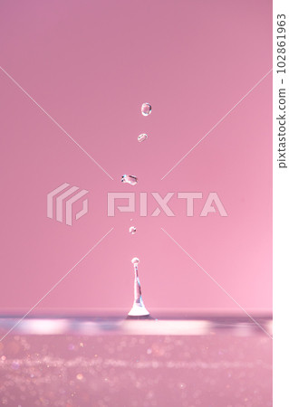 Water droplets fall down closely into the pink water, making it the perfect center in nature Water droplets fall down closely into the pink water, making it the perfect center in nature 102861963